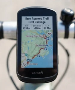Garmin bike computer mounted on handlebars displaying the Rum Runners Trail GPX package map and route details